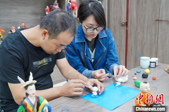 <a target='_blank'  data-cke-saved- >中新社</a>記者(右)現(xiàn)場體驗面塑制作過程。　陳爭強 攝