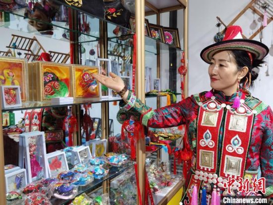 圖為身著民族服飾的隴原巧手展示手工藝品。(資料圖) 徐雪 攝