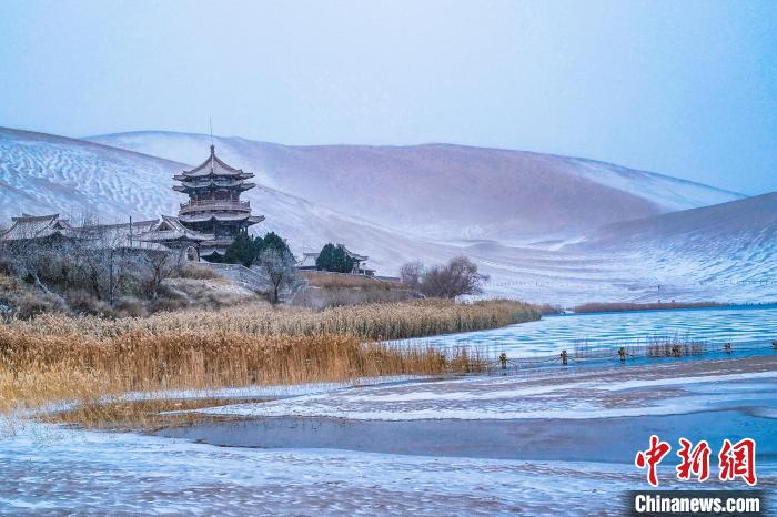 2021年11月28日，雪落鳴沙山月牙泉景區(qū)?！⊥醣筱y 攝