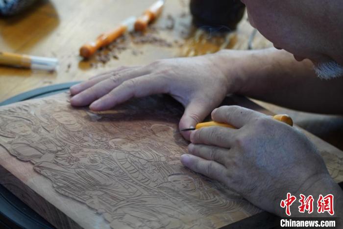 圖為徐晉林湊近木板，近距離制作雕版畫?！【琶赖┰?　攝