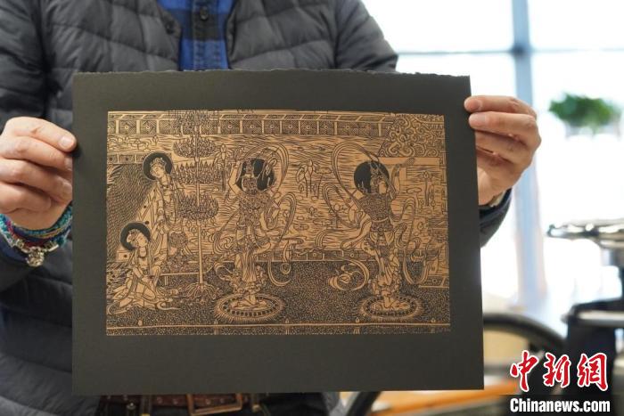 圖為手工書藝人展示敦煌雕版壁畫印刷品?！【琶赖┰?　攝