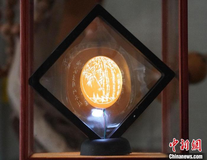 圖為吳義澤新包裝給蛋雕呈現(xiàn)立體感?！【琶赖ぴ?攝