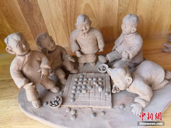 圖為泥塑作品展現(xiàn)下棋場(chǎng)景。 劉玉桃 攝