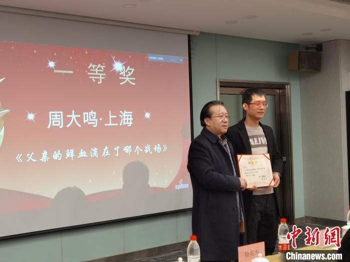 圖為作家、西北師范大學新聞與傳媒學院院長徐兆壽頒發(fā)一等獎證書，代領獎者上臺領獎?！钅?攝