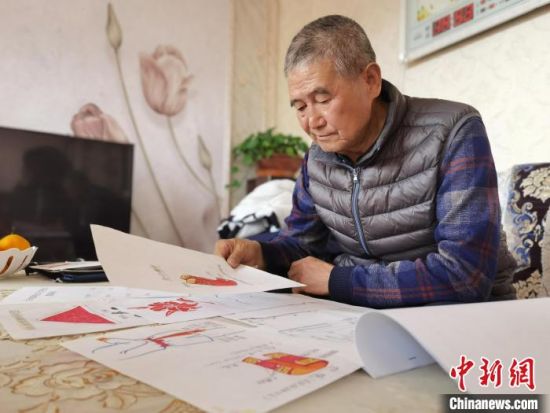 圖為陸鵬飛向記者展示多年帶隊(duì)的手寫筆記?！堟?攝