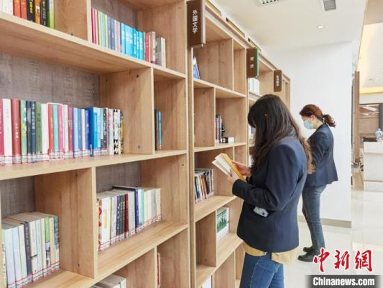 圖為在甘肅公航旅建設集團有限公司的職工書屋，職工挑選書籍。　徐雪 攝