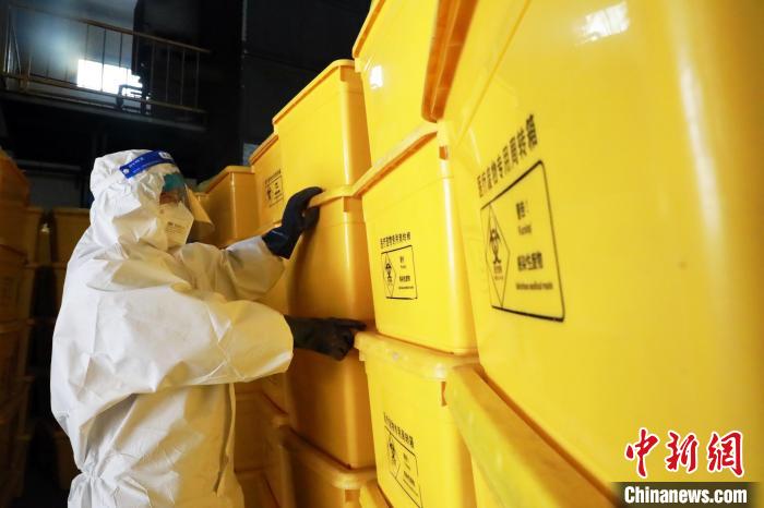 圖為工作人員搬運醫(yī)療廢物專用周轉箱。　魏建軍 攝