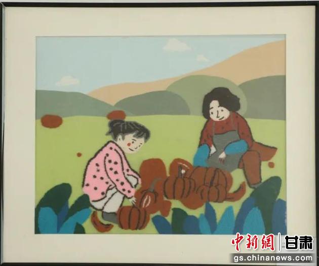 嘉峪關(guān)市新城鎮(zhèn)新城村農(nóng)業(yè)產(chǎn)業(yè)園區(qū)內(nèi)，母女兩人在摘南瓜。刺繡 馬艾米乃 繡稿 敬紅霞