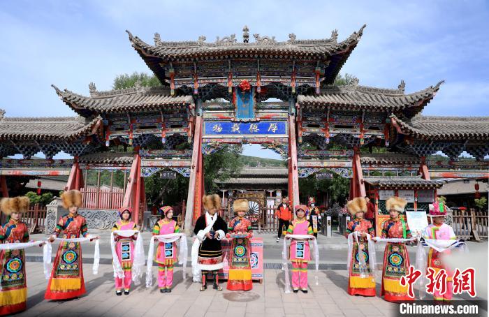 圖為身穿土族服飾的工作人員迎接訪客?！⊙Φ?攝