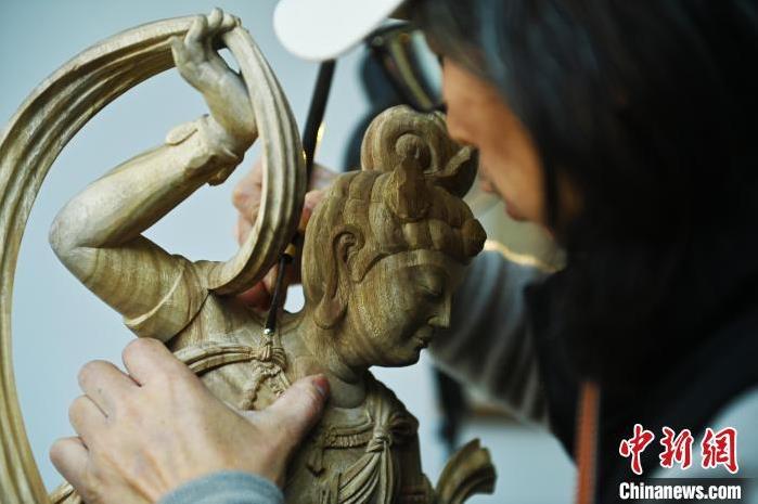 圖為季茂杰進(jìn)行敦煌元素的木雕創(chuàng)作。李亞龍 攝</p>
<p>