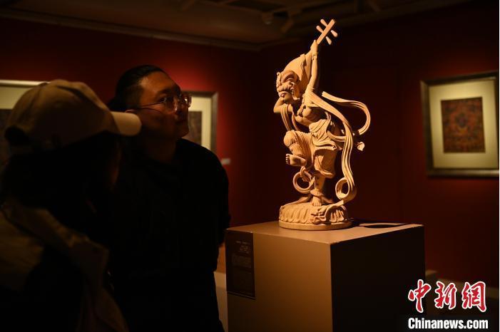 圖為季茂杰向參觀者介紹自己創(chuàng)作敦煌木雕的過(guò)程。李亞龍 攝</p>
<p>