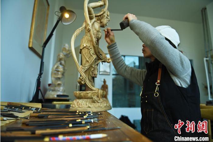 圖為季茂杰進(jìn)行敦煌元素的木雕創(chuàng)作。李亞龍 攝</p>
<p>