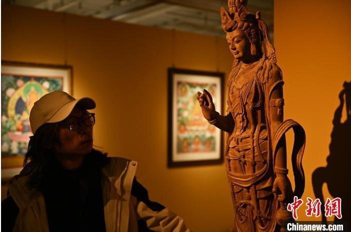 圖為季茂杰觀察自己創(chuàng)作的敦煌木雕。李亞龍 攝</p>
<p>
