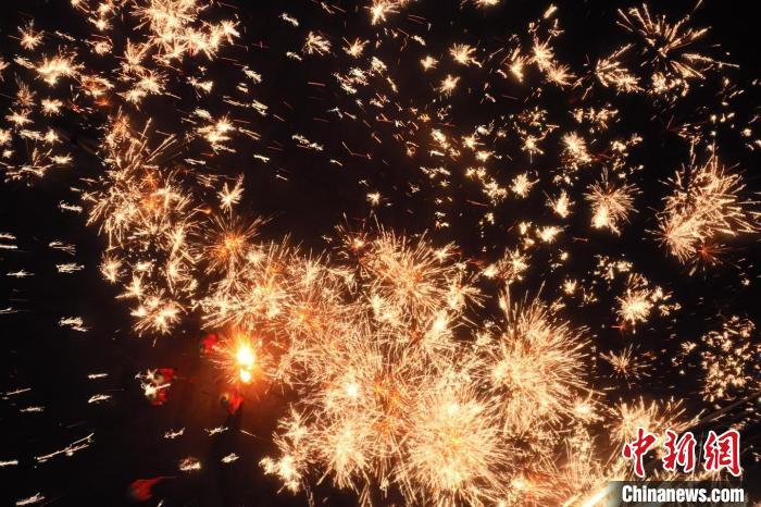 灼熱的鐵水在空中迸散。在空中形成“鐵花火雨”的景象，似天女散花，似群星漫天，如夢如幻，美不勝收。侯奇志 攝</p>
<p>