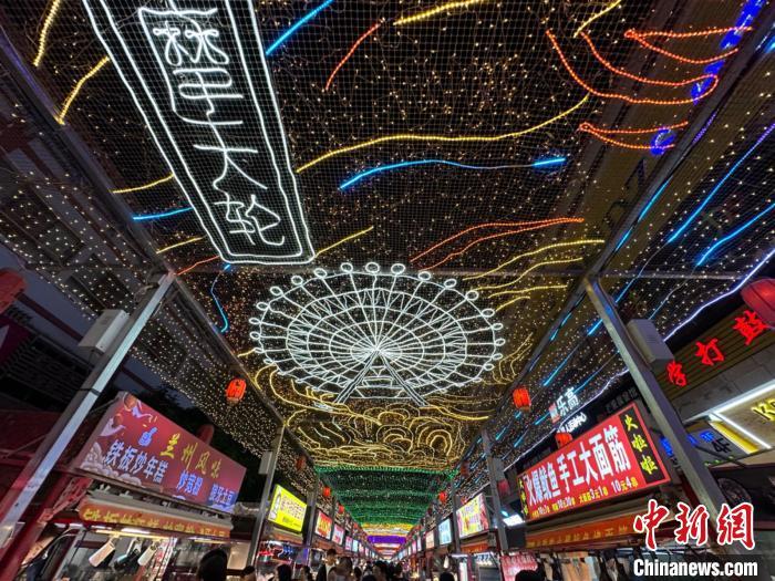 圖為明清街夜市燈光點(diǎn)亮具有武威文化元素的“摩天輪”彩燈?！〈魑牟?攝</p><p>