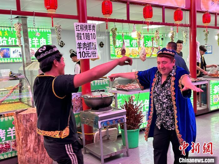 圖為餐飲經(jīng)營(yíng)者在“西涼不夜城”跳起舞蹈引客?！〈魑牟?攝</p><p>