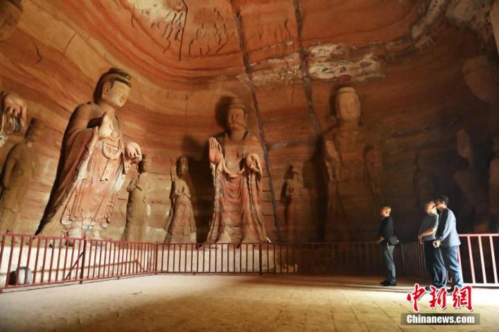 7月15日，游人參觀甘肅省平?jīng)鍪袥艽h百里石窟長(zhǎng)廊中的南石窟寺1號(hào)窟。百里石窟長(zhǎng)廊位于涇川縣境內(nèi)，由512個(gè)石窟、5眼窟中石井組成，現(xiàn)存王母宮石窟、鳳凰山石窟、南石窟寺、丈八寺石窟、羅漢洞石窟、太山寺石窟等規(guī)模較大的石窟群，還有數(shù)量眾多的小石窟群。南石窟寺開(kāi)鑿于北魏永平三年，其中1號(hào)窟屬于大型七佛窟，七佛高達(dá)6米。中新社記者 李亞龍 攝