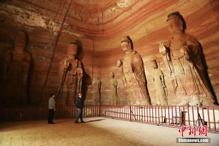 7月15日，游人參觀甘肅省平?jīng)鍪袥艽h百里石窟長(zhǎng)廊中的南石窟寺1號(hào)窟。百里石窟長(zhǎng)廊位于涇川縣境內(nèi)，由512個(gè)石窟、5眼窟中石井組成，現(xiàn)存王母宮石窟、鳳凰山石窟、南石窟寺、丈八寺石窟、羅漢洞石窟、太山寺石窟等規(guī)模較大的石窟群，還有數(shù)量眾多的小石窟群。南石窟寺開(kāi)鑿于北魏永平三年，其中1號(hào)窟屬于大型七佛窟，七佛高達(dá)6米。中新社記者 李亞龍 攝