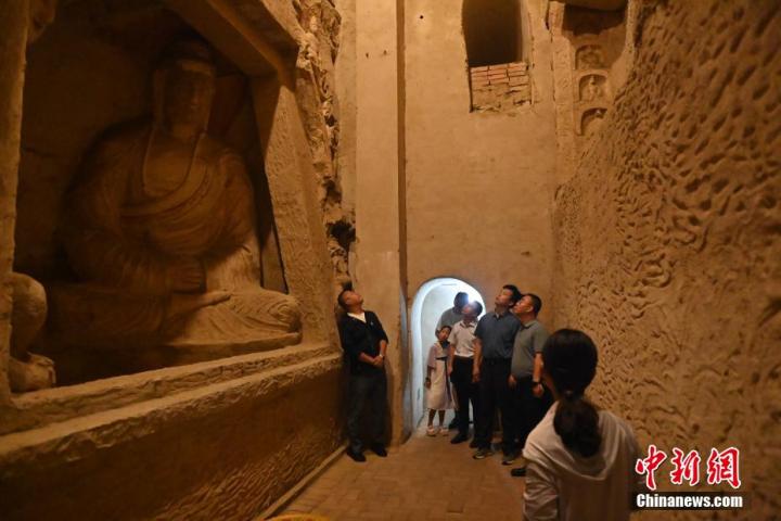 7月15日，游人參觀甘肅省平?jīng)鍪袥艽h百里石窟長(zhǎng)廊中的王母宮石窟。百里石窟長(zhǎng)廊位于涇川縣境內(nèi)，由512個(gè)石窟、5眼窟中石井組成，現(xiàn)存王母宮石窟、鳳凰山石窟、南石窟寺、丈八寺石窟、羅漢洞石窟、太山寺石窟等規(guī)模較大的石窟群，還有數(shù)量眾多的小石窟群。王母宮石窟又名千佛洞，該窟設(shè)計(jì)宏大，造像生動(dòng)，窟內(nèi)擁有造像數(shù)百尊，是較為珍貴的佛教文化歷史遺存。中新社記者 李亞龍 攝</p>
<p>