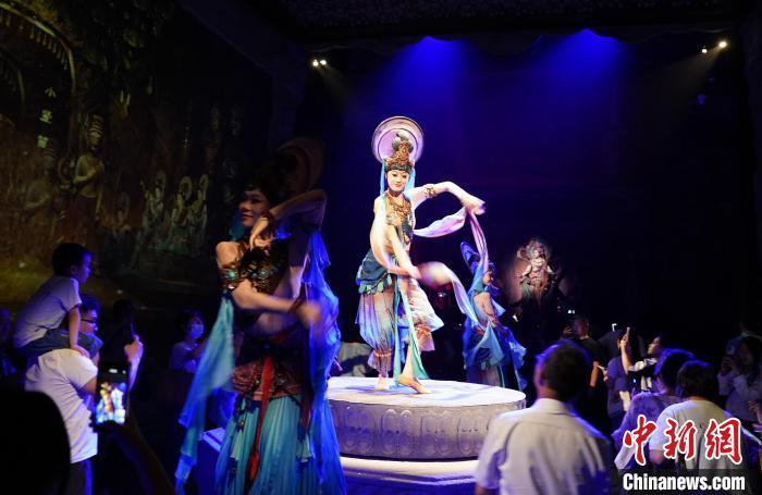 《樂動(dòng)敦煌》是全球首部洞窟式沉浸體驗(yàn)劇，利用真人與數(shù)字影像虛實(shí)交換實(shí)現(xiàn)沉浸式體驗(yàn)。圖為2023年8月28日晚，《樂動(dòng)敦煌》演出。(資料圖)中新社記者 毛建軍 攝