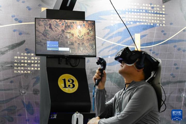 7月22日，游客借助VR設(shè)備沉浸式游覽莫高窟第285窟虛擬場(chǎng)景。新華社記者 郎兵兵 攝